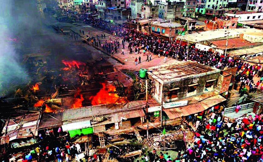 People gather on nearby roads after a fire broke out at a slum in the capital's Mirpur area on Monday.