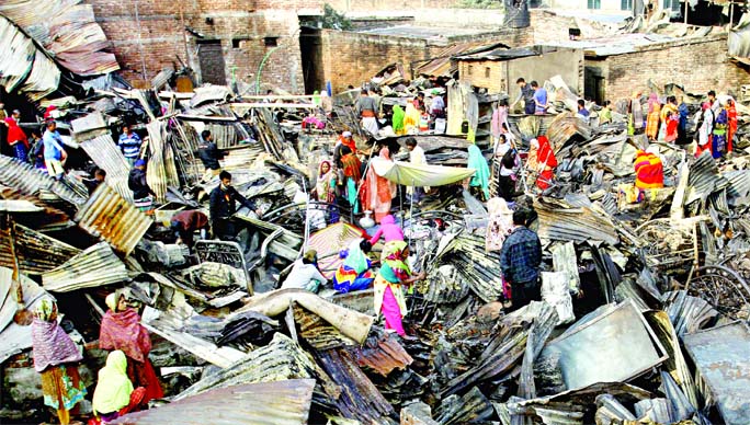 Residents of Taltala slum at Kalshi (Mirpur-11) in Dhaka search for their belongings under the fire ravaged shanties on Tuesday. At least 250 shanties were gutted in a devastating fire in the slum on Monday afternoon.