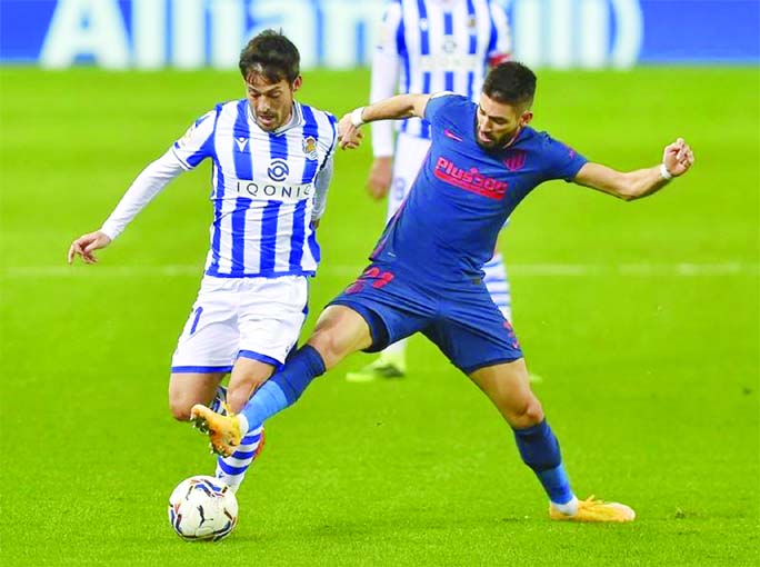 Atletico Madrid's Belgian midfielder Yannick Carrasco (right) vies with Real Sociedad's Spanish midfielder David Silva during the Spanish league football match between Real Sociedad and Club Atletico de Madrid at the Anoeta stadium in San