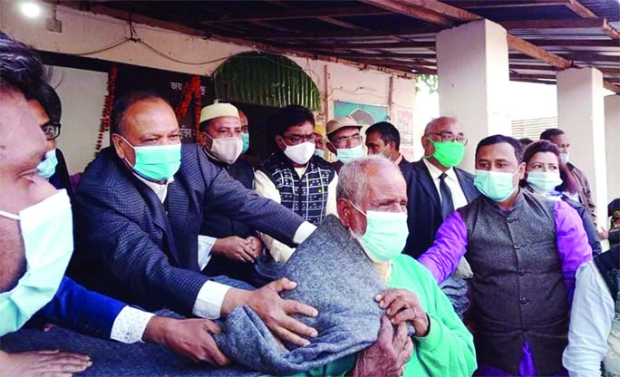 Leaders of Rangpur District Awami League distribute blankets among the 500 cold-hit people at a ceremony on the district Awami League office premises at Betpatti in the city on Wednesday afternoon.