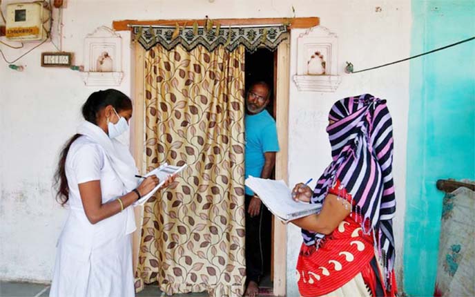 Photo of health workers in Ahmedabad collecting personal data from a man as they prepare a list during a door-to-door survey for the coronavirus vaccination drive in India.