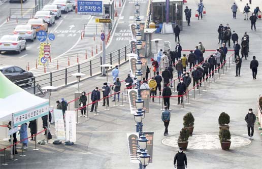 People queuing in line to wait for coronavirus testing while maintaining social distancing at coronavirus testing site in Seoul, South Korea.