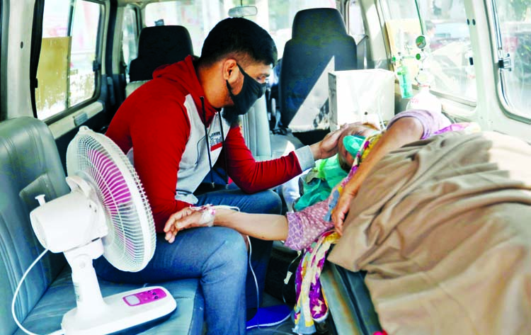 An elderly woman with oxygen support waits inside an ambulance for a token so that she can give her swab sample for Covid-19 testing. This photo was taken from in front of Dhaka Medical College and Hospital on Sunday.