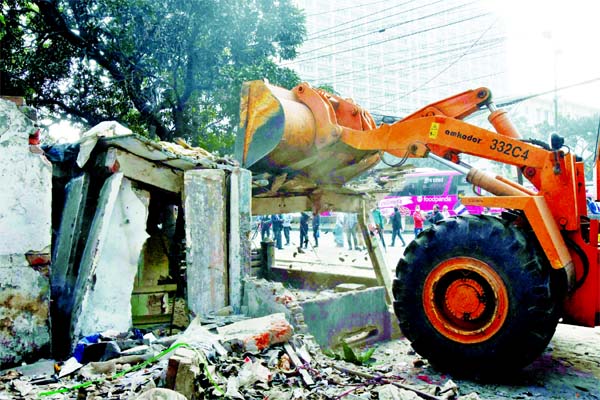 A DSCC bulldozer knocks down an illegal establishment from the capital's Muktangon area in a drive on Sunday.