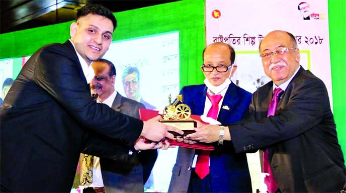 Ishmam Salam, Director of Envoy Group Limited, receiving the 'President's Industrial Development Award 2018' from Industries Minister Nurul Majid Mahmud Humayun MP at the Pan Pacific Sonargaon Hotel in the city on Monday.