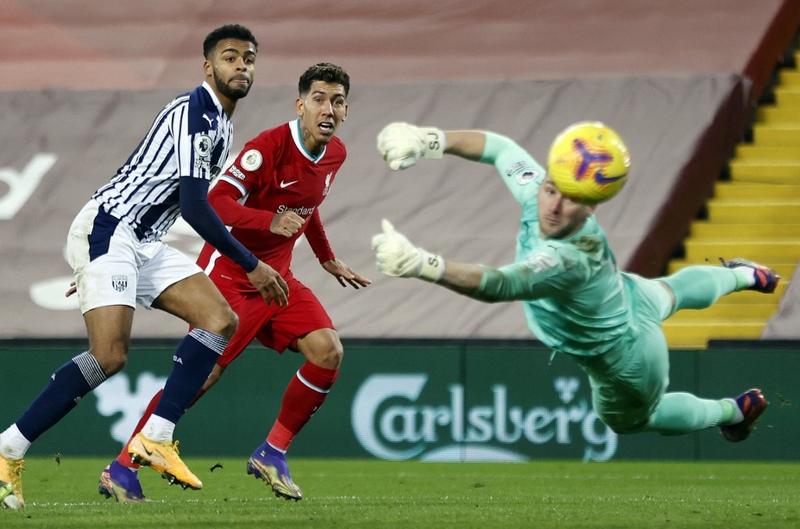 Liverpool's midfielder Roberto Firmino (center) heads wide past West Bromwich Albion's goalkeeper Sam Johnston (right) during the English Premier League football match between Liverpool and West Bromwich Albion at Anfield in Liverpool, north west Englan