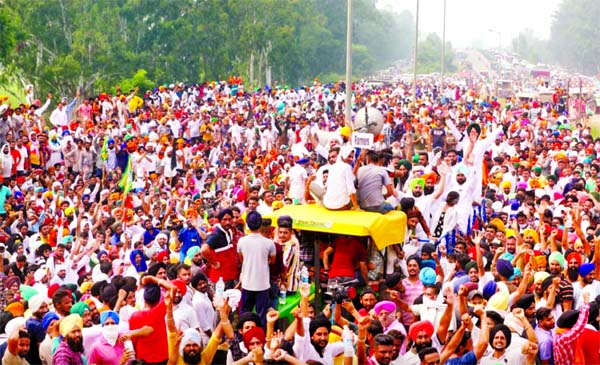 Farmers gesture as they block a national highway during a protest against farm bills passed by India's parliament, in Shambhu in the northern state of Punjab, India.