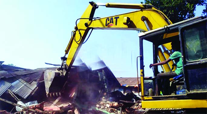 A bulldozer of Bangladesh Railway evicts illegal structures from railway land at the Jor Deba area, Pahartali, in Chottogram city on Sunday.