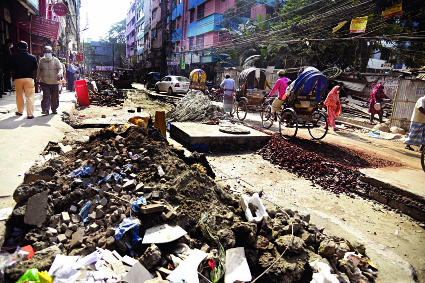 Pedestrians and vehicles have to pass through a broken road in the capital's Zigatola area with huge inconvenience everyday due to apathy of authorities concern to complete the road's repair work. This photo was taken on Thursday.