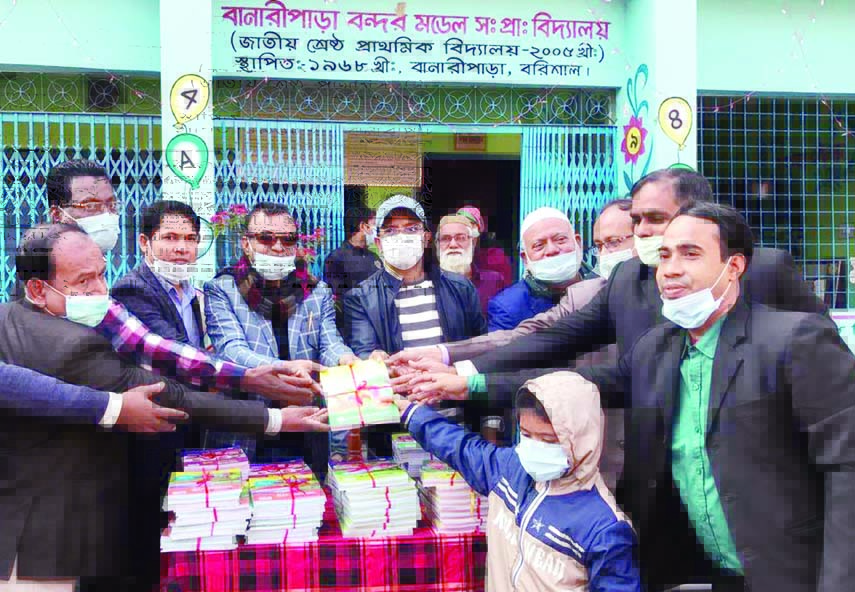 Banaripara Upazila (Barishal) Chairman Golam Faruk distributes textbooks among the students of Banaripara Model Government Primary School on the first day of New Year (Friday) following health safety measures amid the novel coronavirus pandemic situation.