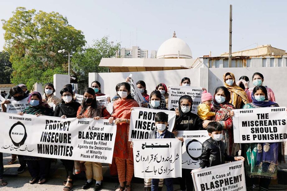 People from the Hindu community hold signs and banners to condemn the attack on a century-old Hindu temple in northwestern Pakistan, during a protest outside Supreme Court building in Karachi, Pakistan.