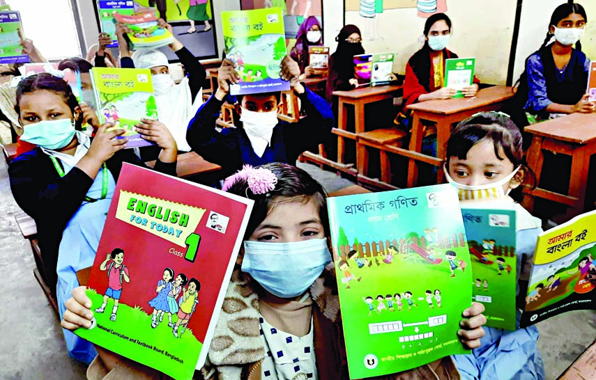 Students cheer with new books at the Municipality Model Government Primary School in the capital on Friday as a nationwide free textbook distribution begins on the first day of New Year keeping up with a decade-long tradition.