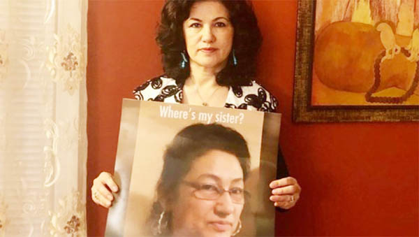 Rushan Abbas holds up a photo of her sister, Gulshan Abbas, in a photo posted to social media.