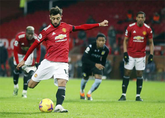 Manchester United's Bruno Fernandes shoots and scores his side's second goal from the penalty spot during the English Premier League soccer match between Manchester United and Aston Villa at Old Trafford in Manchester, England on Friday.