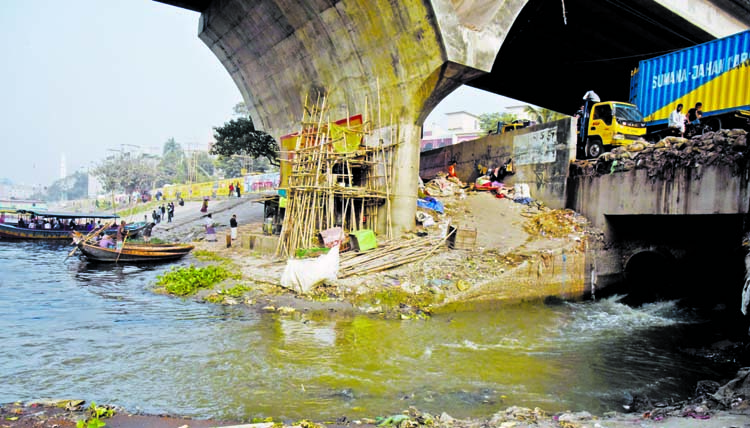 Waste mixed water continues to flow in the Buriganga River despite the government efforts to make the river free of pollution. This photo was taken from the capital's Babubazar area on Monday.