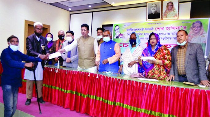 Advocate Nasir Uddin Khan, Secretary General of Sylhet District Awami League, distributes cheques of financial aid to the physically challenged and sick persons from Prime Minister's fund on Thursday.