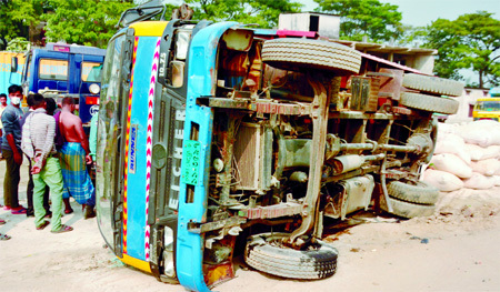 A goods laden truck turns turtle being driven recklessly at Demra Basherpool area in the capital on Thursday.