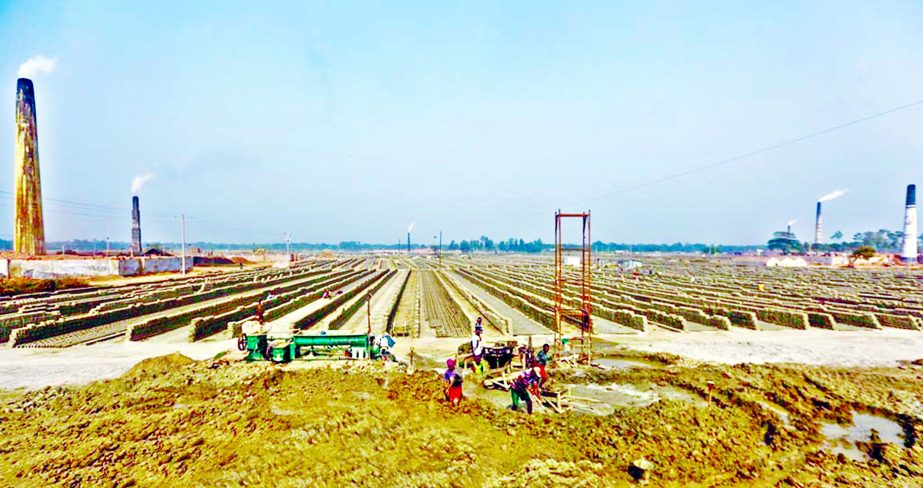 Workers are preparing the ground for making bricks at a brickfield in Manikganj as bricks are still made in Bangladesh using traditional methods. This photo was taken yesterday.