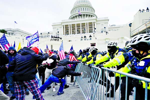 Trump supporters try to break through a police barrier at the Capitol in Washington, DC.