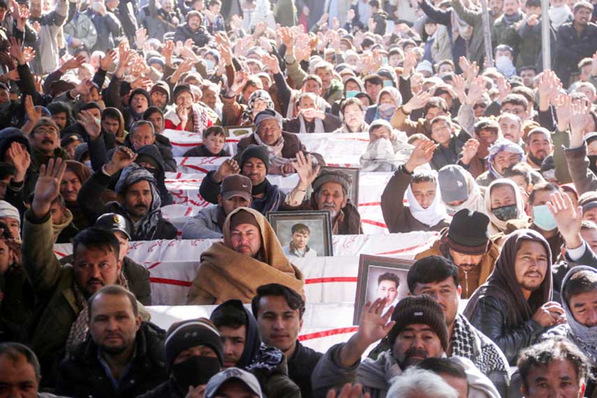 People chant slogans as they sit with coffins of their relatives, coal miners from the Shia Hazara minority killed in an attack.