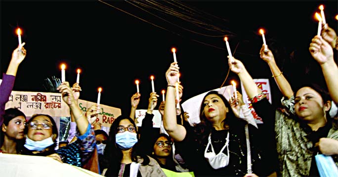 Guardians and students of capital's Mastermind School hold candles and a banner as they participate in a candle lit procession in city's Dhanmondi area on Saturday evening seeking justice for Anushka Noor Amin, following her rape and murder.