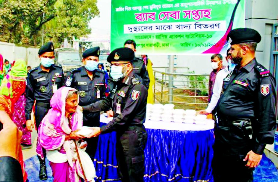 Members of RAB-10 distribute foods among destitute people marking the Homecoming Day of the Father of the Nation Bangabandhu Sheikh Mujibur Rahman at Dhalpur, Jatrabari in the capital on Sunday.