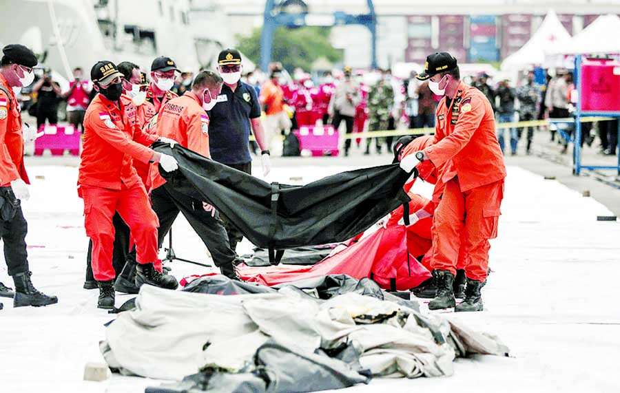 Rescuers lay out body bags containing human remains recovered from the crash site of Sriwijaya Air flight SJ182 at the port, in Jakarta on Sunday.