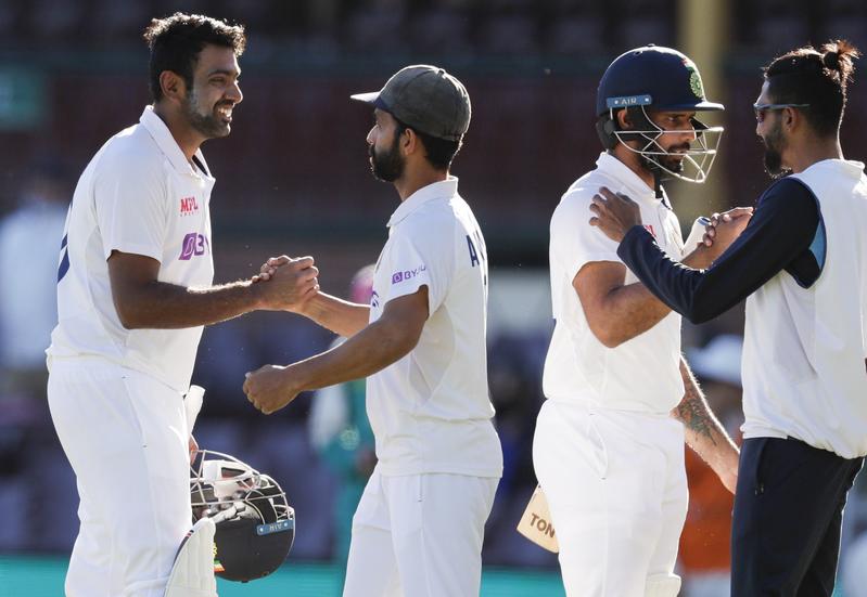 India's Ravichandran Ashwin (left) is congratulated by his captain Ajinkya Rahane as Hanuma Vihari is congratulated by teammate Mohammed Siraj (right) following play on the final day of the third cricket test between India and Australia at the Sydney Cri