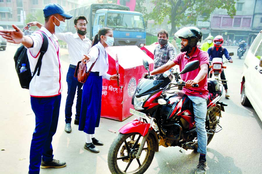 Members of Bangladesh Scouts direct a biker to follow traffic rules at Bongo Bazar intersection in the capital on Monday amid traffic disorder in city.