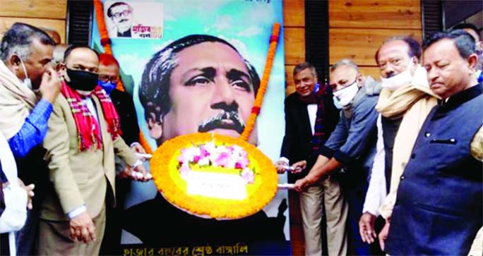 Chandpur District AL President Nasiruddin Ahmed and Secretary Abu Nayeem Patwary Dulal along with other leaders place floral wreaths at the bottom of Bangabandhu Sheikh Mujibur Rahman's portrait in party office on Sunday marking his historic Homecoming D