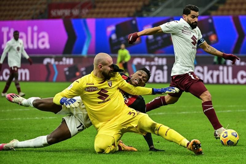 Torino's goalkeeper Vanja Milinkovic-Savic (front) and AC Milan's forward Rafael Leao collide as Torino's midfielder Tomas Rincon (right) goes for the ball during the Italian Cup round of sixteen football match at the San Siro stadium in Milan on Tuesd