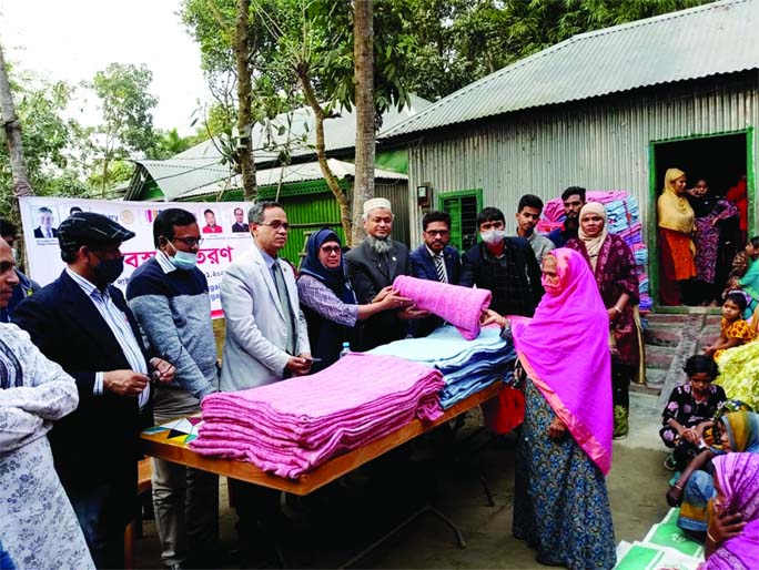 Dr Mohammad Harun-Ar-Rashid, Rotary Club, Tangail City President, distributes blanket among the cold-hit people at Dainya Union in Tangail Sadar Upazila on Wednesday.