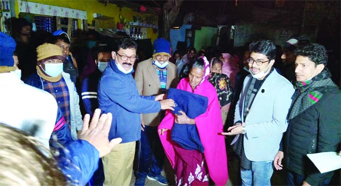 Deputy Commissioner (DC) of Chapainawabganj Md. Manjurul Hafiz distributes blankets among the poor cold-hit people of Harijon Palli at Balubagan Nimtala area in the town on Wednesday night.