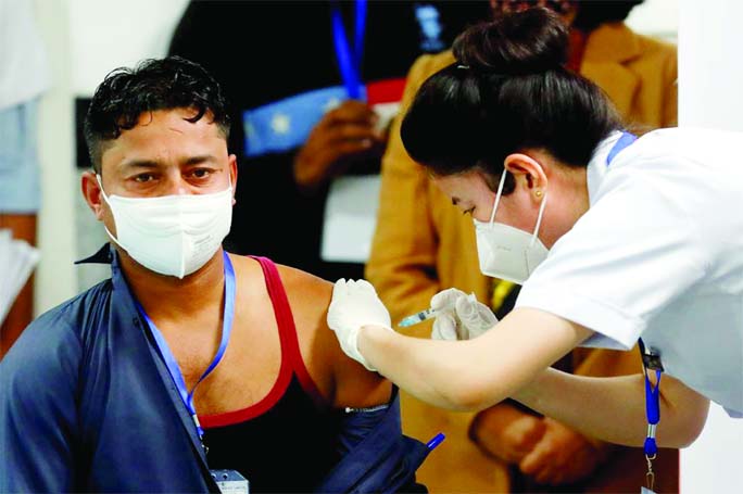 Sanitation worker Manish Kumar, who according to the officials is the first person in the country vaccinated against the Covid-19, receives a dose of Bharat Biotech's COVAXIN during the vaccination campaign at All India Institute of Medical Sciences (AII