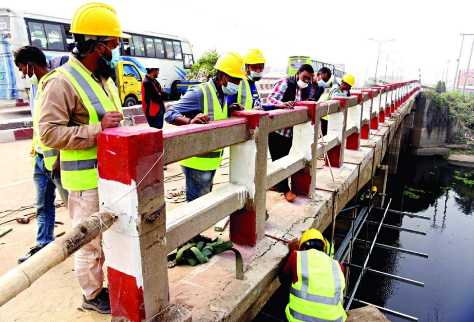 Engineers of Roads and Highways Department examine cracks on Salehpur Bridge near Aminbazar in Dhaka while carrying out repairing works of the bridge on Saturday.