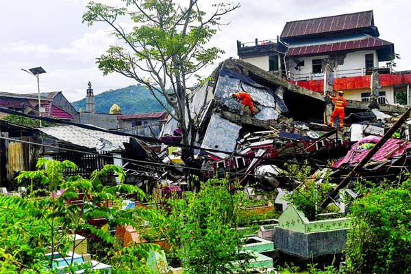 Search and rescue personnel inspect a collapsed building following an earthquake in Mamuju, West Sulawesi province, Indonesia.