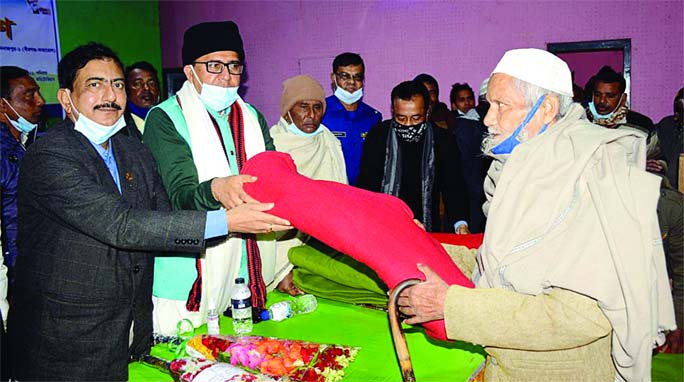Manoranjan Shill Gopal, MP, distributes blanket among the cold-hit people at a ceremony at the Kaharole Upazila Parishad Hall room in Dinajpur district on Saturday.