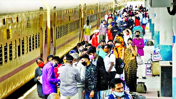 People gather at a train station wearing masks in India amid coronavirus.