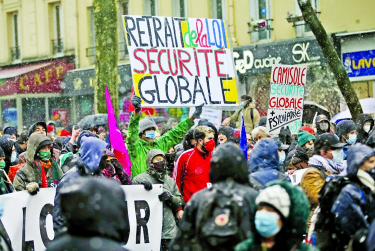 Demonstrators, most wearing masks to protect against COVID-19, during a protest against the controversial security bill in Paris.