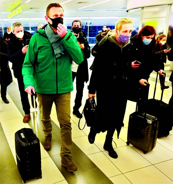 Russian opposition leader Alexei Navalny and his wife, Yulia Navalnaya, walk toward passport control at Moscow's Sheremetyevo airport.