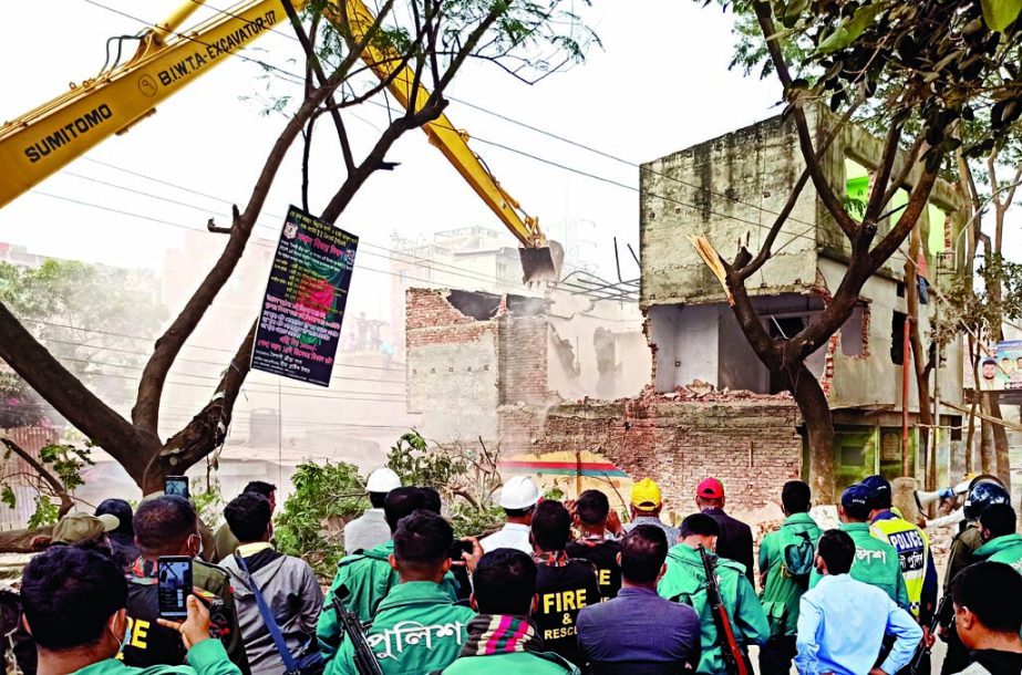 A hydraulic crane demolishes a multi-storey building from the bank of Buriganga River at Kamrangirchar area in the capital on Tuesday as the Bangladesh Inland Water Transport Authority (BIWTA) launched an eviction drive to realm the river lands.