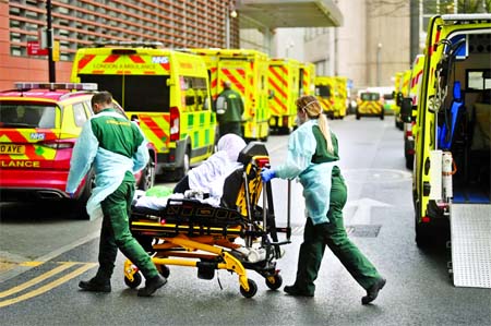 Medical workers transfer a patient from an ambulance to the Royal London Hospital in London, Britain.