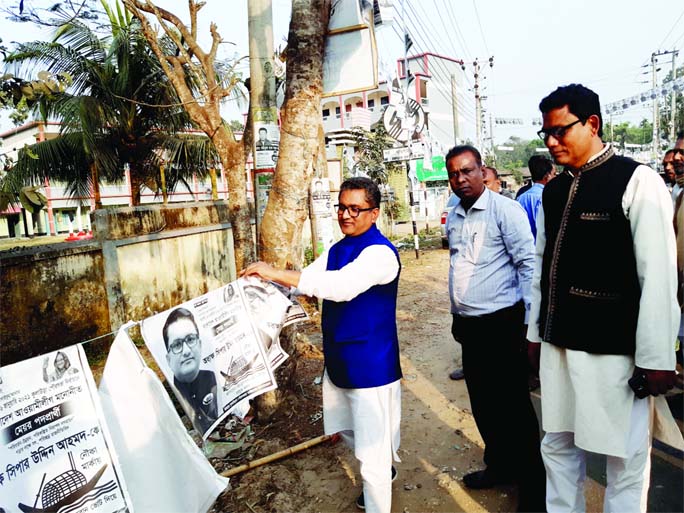 Newly elected Kulaura Municipality Mayor Shipar Uddin Ahmod removes his electoral posters from different area in Kulaura town in Moulvibazar district on Sunday afternoon.