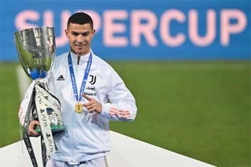 Juventus' forward Cristiano Ronaldo poses with the winners' trophy after the Italian Super Cup football match against Napoli at the Mapei stadium - Citta del Tricolore in Reggio Emilia on Wednesday.