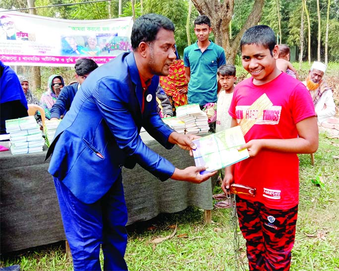 A child with special needs is receiving a new book at Khanmorich Disabled School in Bhangura Upazila of Pabna district on Wednesday.