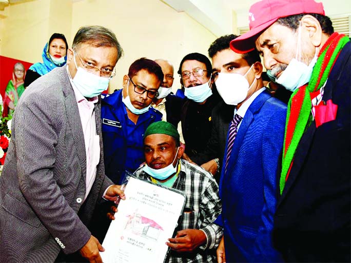 On behalf of Prime Minister Sheikh Hasina, Information Minister Dr Hasan Mahmud hands over deeds of houses and land among the landless families in Rangunia, Chattogram on Saturday marking 'Mujib Year'.