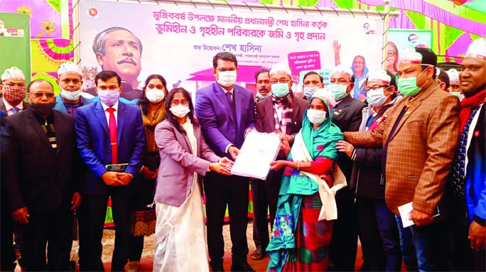 Rangpur DC Md Asib Ahsan hands over keys and documents of houses among the landless families in Gangachara Upazila in the district at a ceremony held on the upazila premises on Saturday. A total of 100 homeless families in the upazila got shelters as a gi