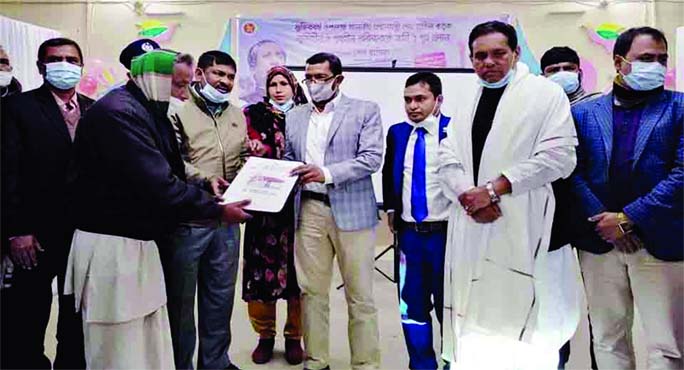 Rana Mohammad Sohel, MP, hands over documents of home to a homeless person at a ceremony held in the Jaldhaka upazila auditorium in Nilphamari on Saturday morning. A total of 191landless and homeless families of the upazila received shelters as a gift fro