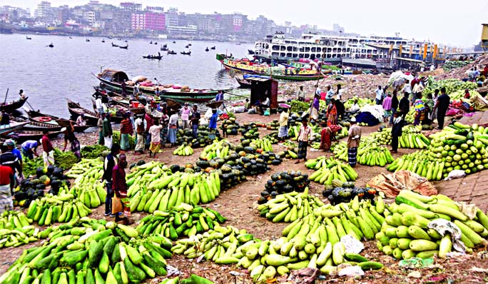 Wide varieties of vegetables come from the surrounding areas of Dhaka in the every early morning through the Buriganga River due to low transport cost. This photo taken on Saturday morning shows that traders pile up vegetables at the capital's Swarighat