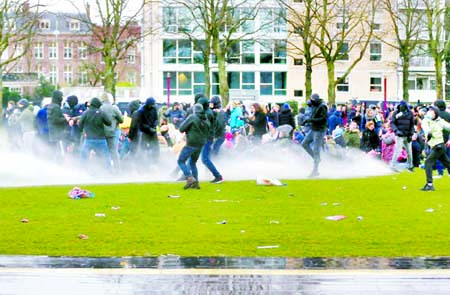 Police use a water canon during a protest against restrictions put in place to curb the spread of the coronavirus in Amsterdam, Netherlands.